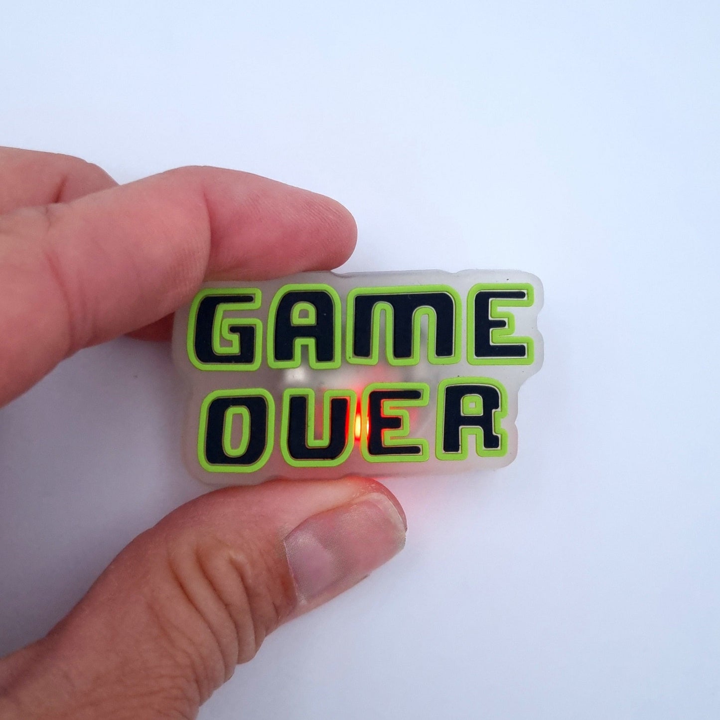 Crocs Button mit LED Beleuchtung und Game Over Motiv.