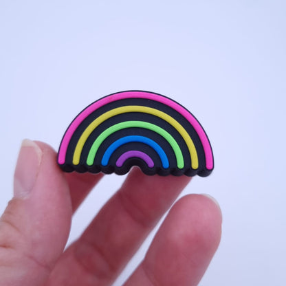 Hand hält Crocs Schmuck neon Regenbogen