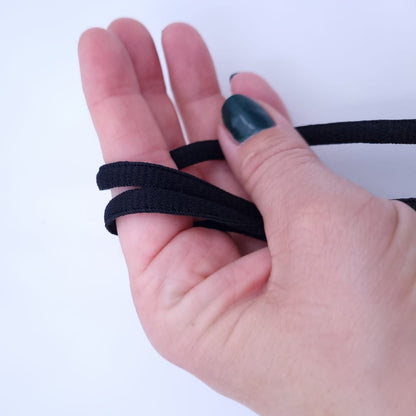 Hand hält halbrunde, schwarze Schnürsenkel