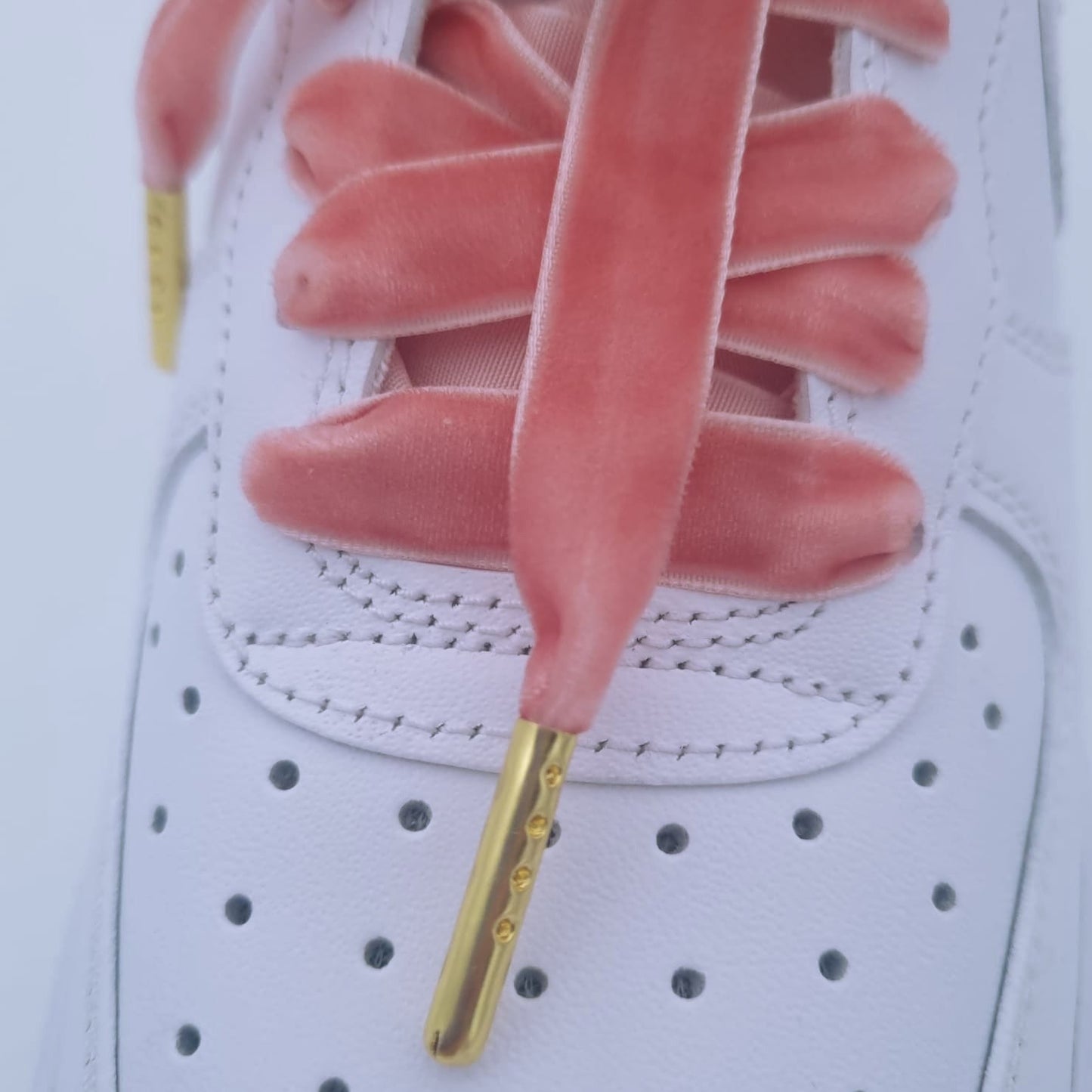 Samt Schnürsenkel in rosa auf weißen AF1 Sneakern.